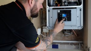 Image of an Rj Martindale engineer servicing a boiler at a home in Bolton
